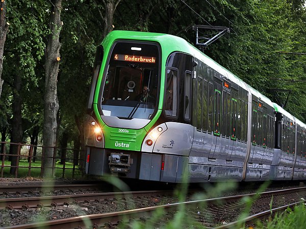 Eine ÜSTRA Stadtbahn der Linie 4 fährt auf den Schienen. 